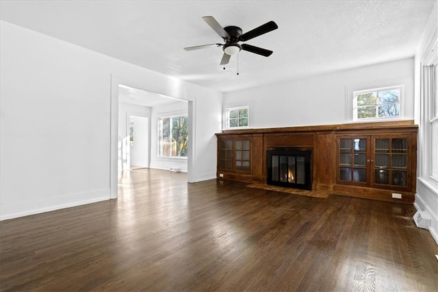 unfurnished living room featuring ceiling fan and dark hardwood / wood-style floors