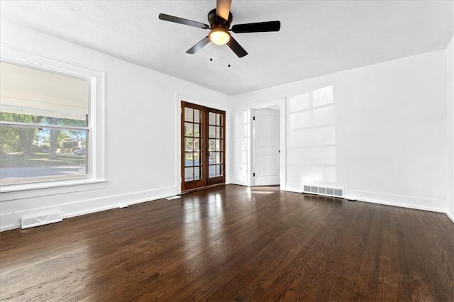 spare room with a wealth of natural light, french doors, dark wood-type flooring, and ceiling fan