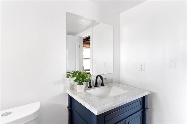 bathroom with vanity, a textured ceiling, and toilet