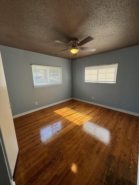 empty room with wood-type flooring, ceiling fan, and a textured ceiling