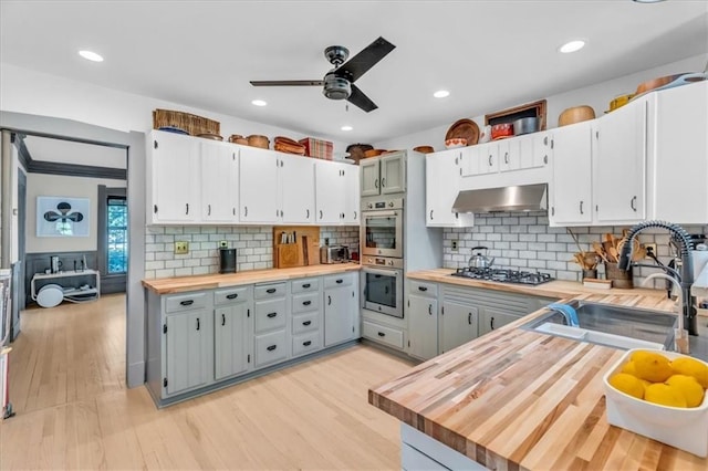 kitchen featuring gray cabinets, sink, and butcher block counters