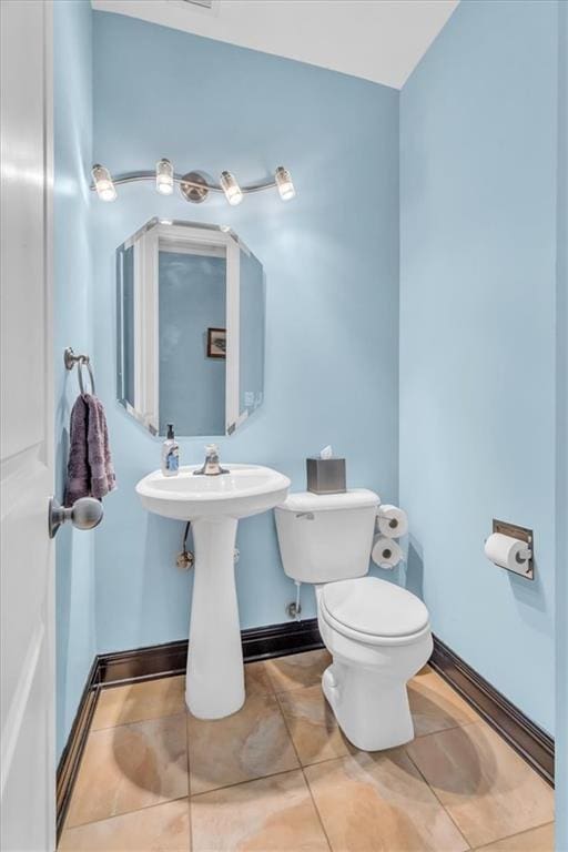 bathroom with toilet and tile patterned floors