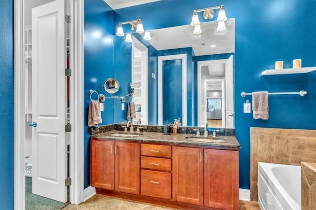 bathroom with a tub to relax in, tile patterned flooring, and vanity