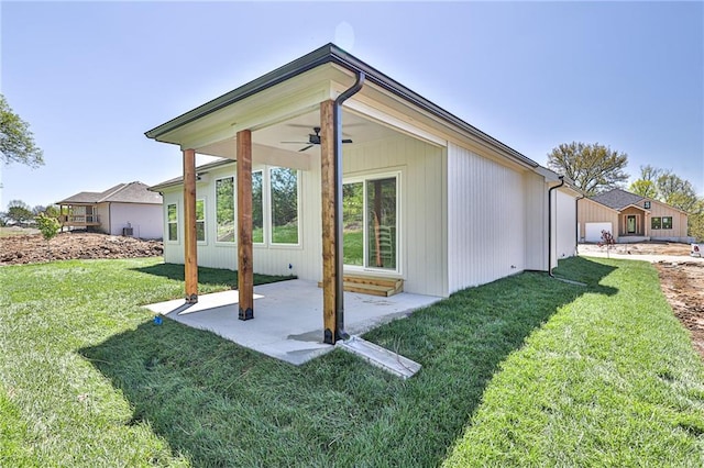 back of property with ceiling fan, a lawn, and a patio