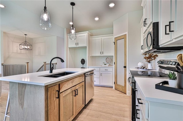 845 Willow Tree Ct, Higginsville, MO 64037 - kitchen featuring appliances with stainless steel finishes, a sink, tasteful backsplash, light wood-style floors, and light countertops