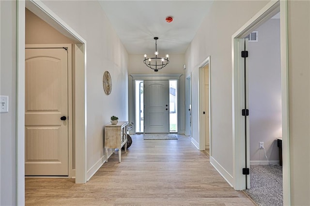 845 Willow Tree Ct, Higginsville, MO 64037 - entryway with light wood-style floors, a chandelier, and baseboards