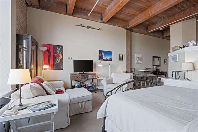 carpeted bedroom featuring a high ceiling, beamed ceiling, and wooden ceiling