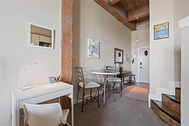 dining space featuring wooden ceiling, a high ceiling, baseboards, and beam ceiling