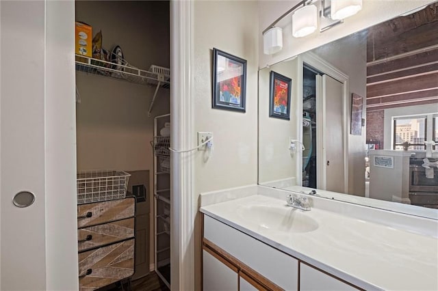 bathroom with a spacious closet and vanity