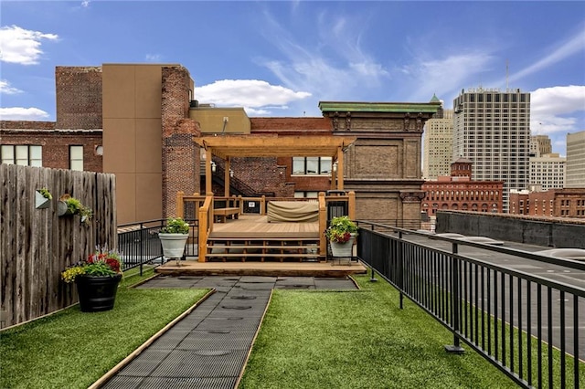 exterior space featuring a view of city, a yard, fence, and a wooden deck