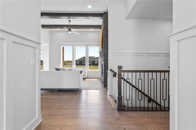 corridor featuring beam ceiling and dark hardwood / wood-style flooring