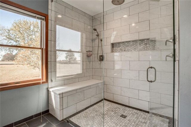 bathroom with walk in shower and tile patterned flooring