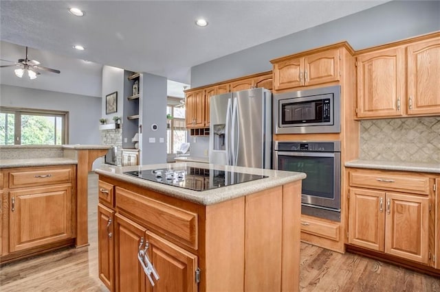 kitchen with light hardwood / wood-style floors, a center island, stainless steel appliances, and plenty of natural light