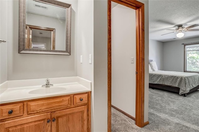 bathroom with vanity, a textured ceiling, and ceiling fan