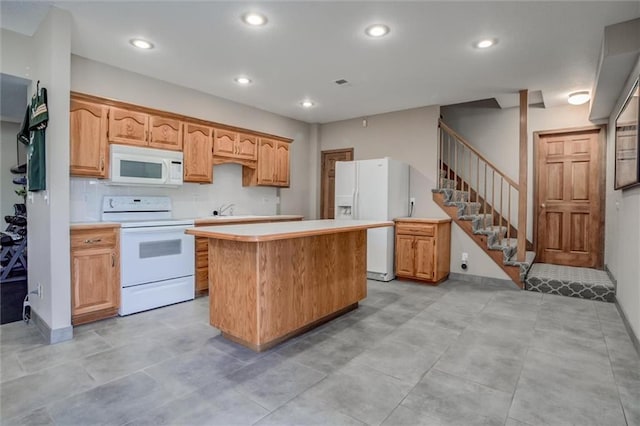 kitchen with white appliances, a center island, and sink