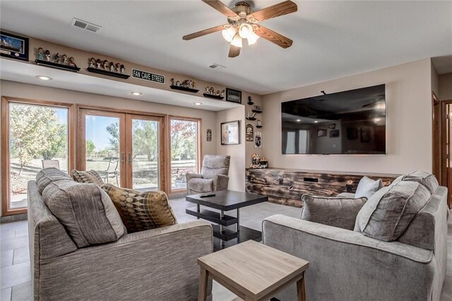 tiled living room with french doors and ceiling fan