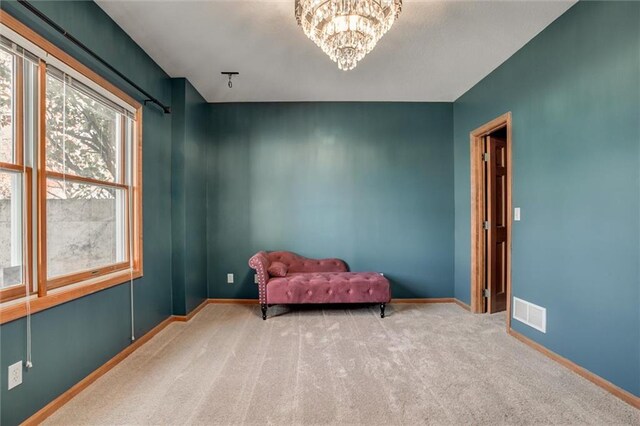 sitting room featuring a notable chandelier and carpet flooring