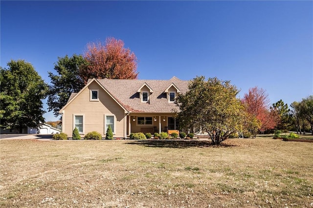 cape cod home with a front lawn and a garage