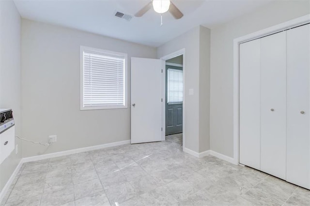 unfurnished bedroom featuring ceiling fan and a closet