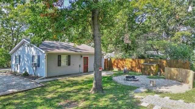 view of front of house with a front yard, a patio area, and an outdoor fire pit