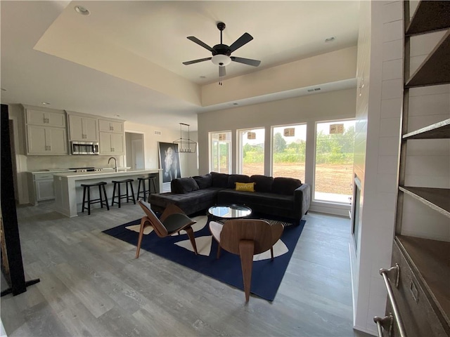 living room with sink, ceiling fan, and hardwood / wood-style floors