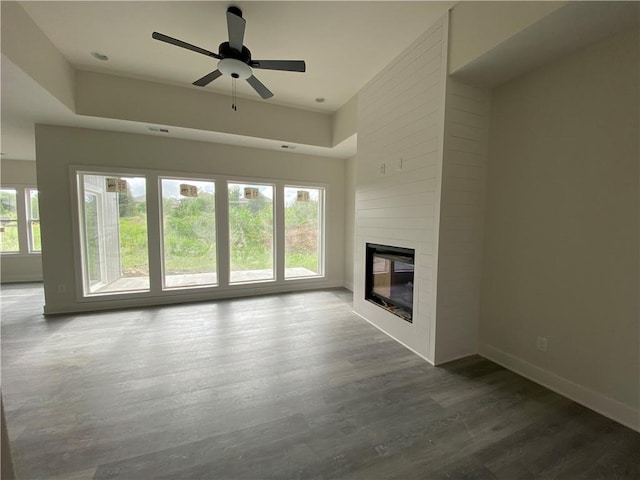 unfurnished living room featuring a large fireplace, ceiling fan, and hardwood / wood-style floors