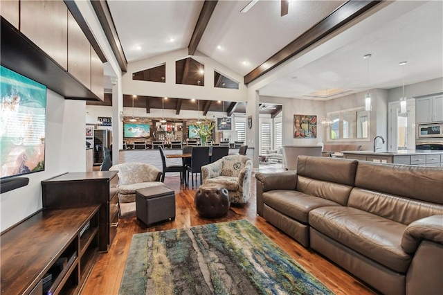 living room featuring sink, hardwood / wood-style floors, vaulted ceiling with beams, and plenty of natural light