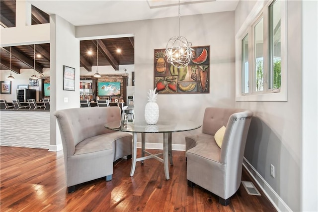 dining room featuring vaulted ceiling with beams, dark wood-type flooring, a notable chandelier, and wood ceiling