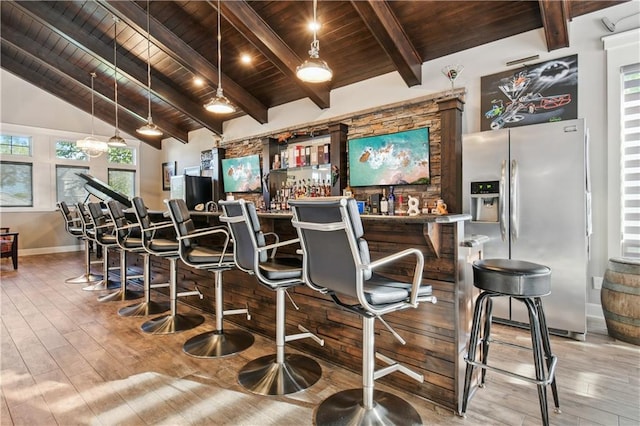 bar featuring lofted ceiling with beams, wood-type flooring, wooden ceiling, and stainless steel fridge with ice dispenser