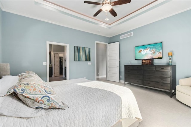 carpeted bedroom with ceiling fan, crown molding, and a raised ceiling