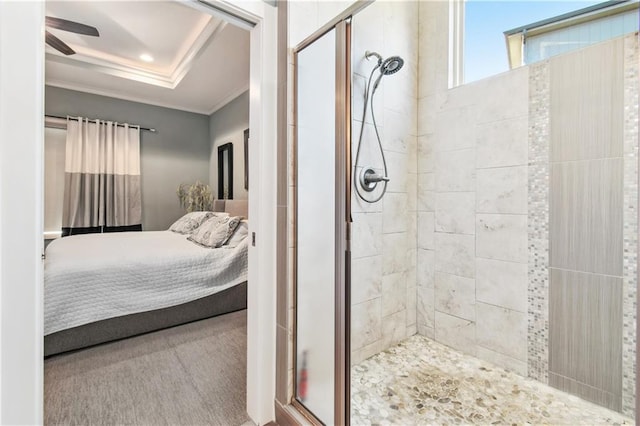 bathroom with an enclosed shower, ceiling fan, and a raised ceiling