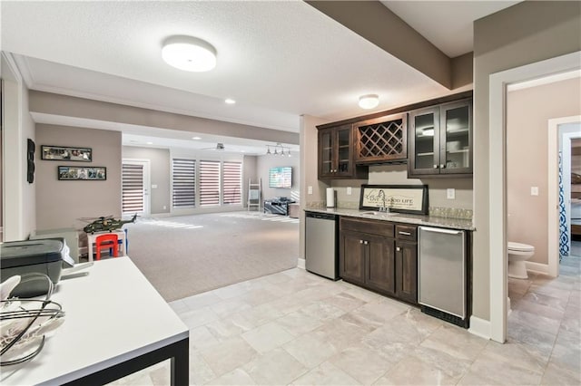 kitchen featuring a textured ceiling, light colored carpet, dark brown cabinets, and stainless steel appliances