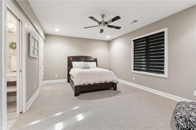 bedroom with light colored carpet, ceiling fan, and ensuite bath