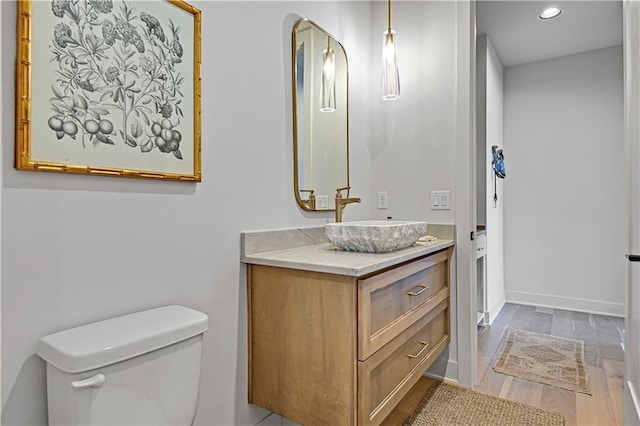 bathroom featuring hardwood / wood-style flooring, vanity, and toilet