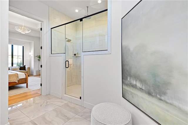 bathroom with a chandelier and a shower with door