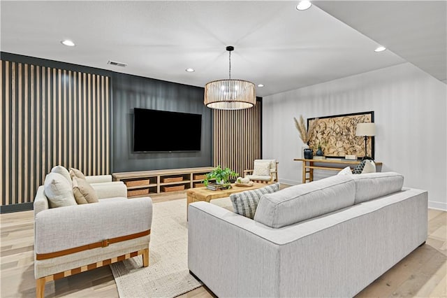 living room with an inviting chandelier and light hardwood / wood-style flooring