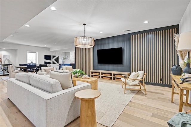 living room with light hardwood / wood-style flooring and a notable chandelier