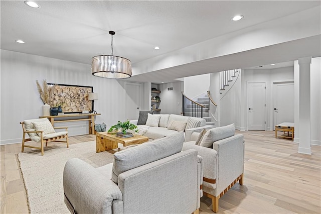 living room featuring light hardwood / wood-style floors and a notable chandelier