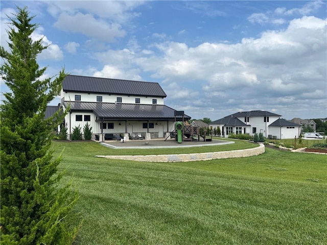 rear view of property with a lawn and a patio