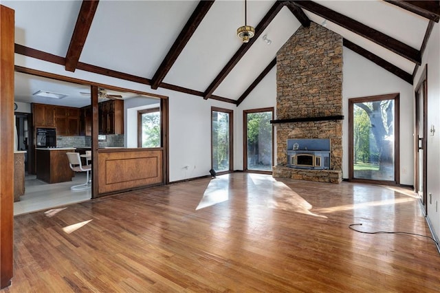 unfurnished living room with plenty of natural light, light hardwood / wood-style floors, and high vaulted ceiling