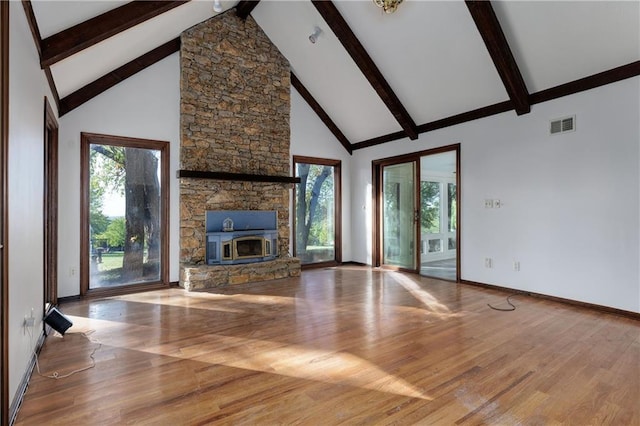 unfurnished living room with beamed ceiling, hardwood / wood-style flooring, and high vaulted ceiling