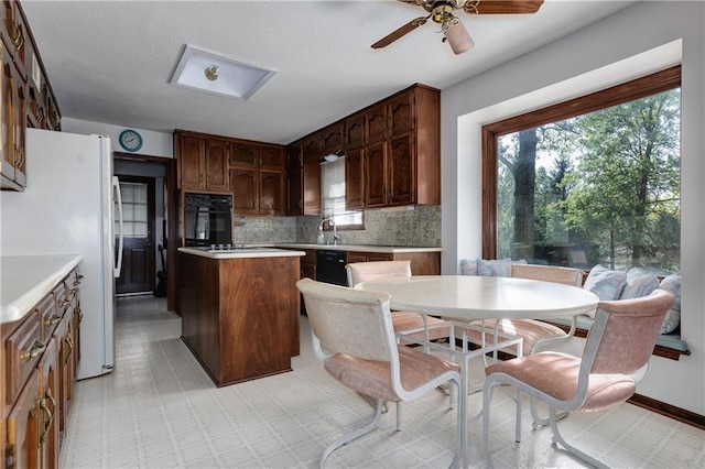 kitchen with ceiling fan, tasteful backsplash, dark brown cabinets, sink, and black appliances