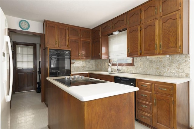 kitchen featuring a kitchen island, sink, decorative backsplash, and black appliances