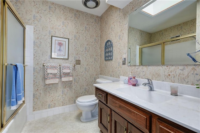 full bathroom featuring tile patterned flooring, bath / shower combo with glass door, vanity, and toilet