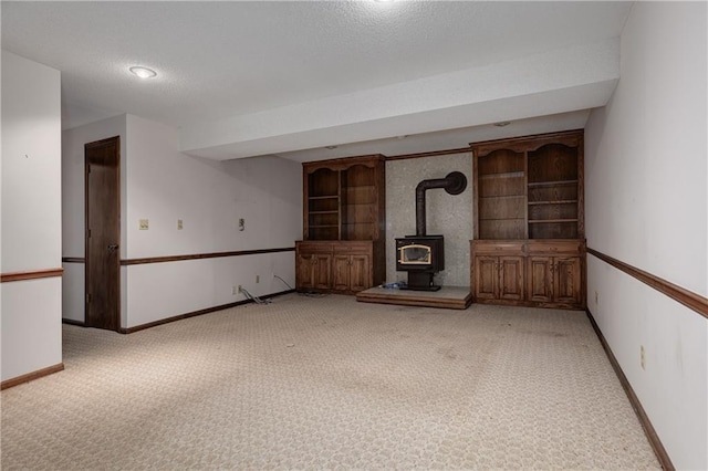 unfurnished living room with light colored carpet, a textured ceiling, and a wood stove