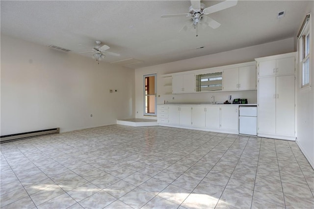 unfurnished living room featuring ceiling fan and a baseboard heating unit