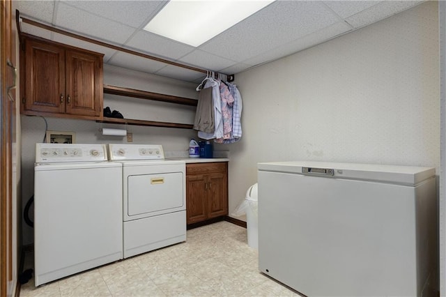 laundry room featuring washer and dryer and cabinets