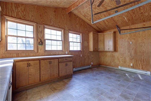 laundry room featuring wood walls, a baseboard heating unit, and a healthy amount of sunlight