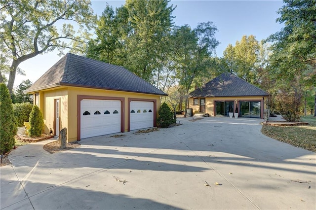 view of front facade featuring a garage and an outbuilding