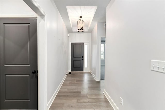 corridor featuring a notable chandelier and light hardwood / wood-style flooring